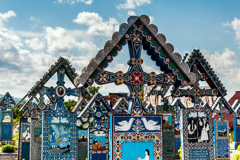 Imagine ce reprezinta un ansamblu de cruci din Cimitirul Vesel de la Sapanta